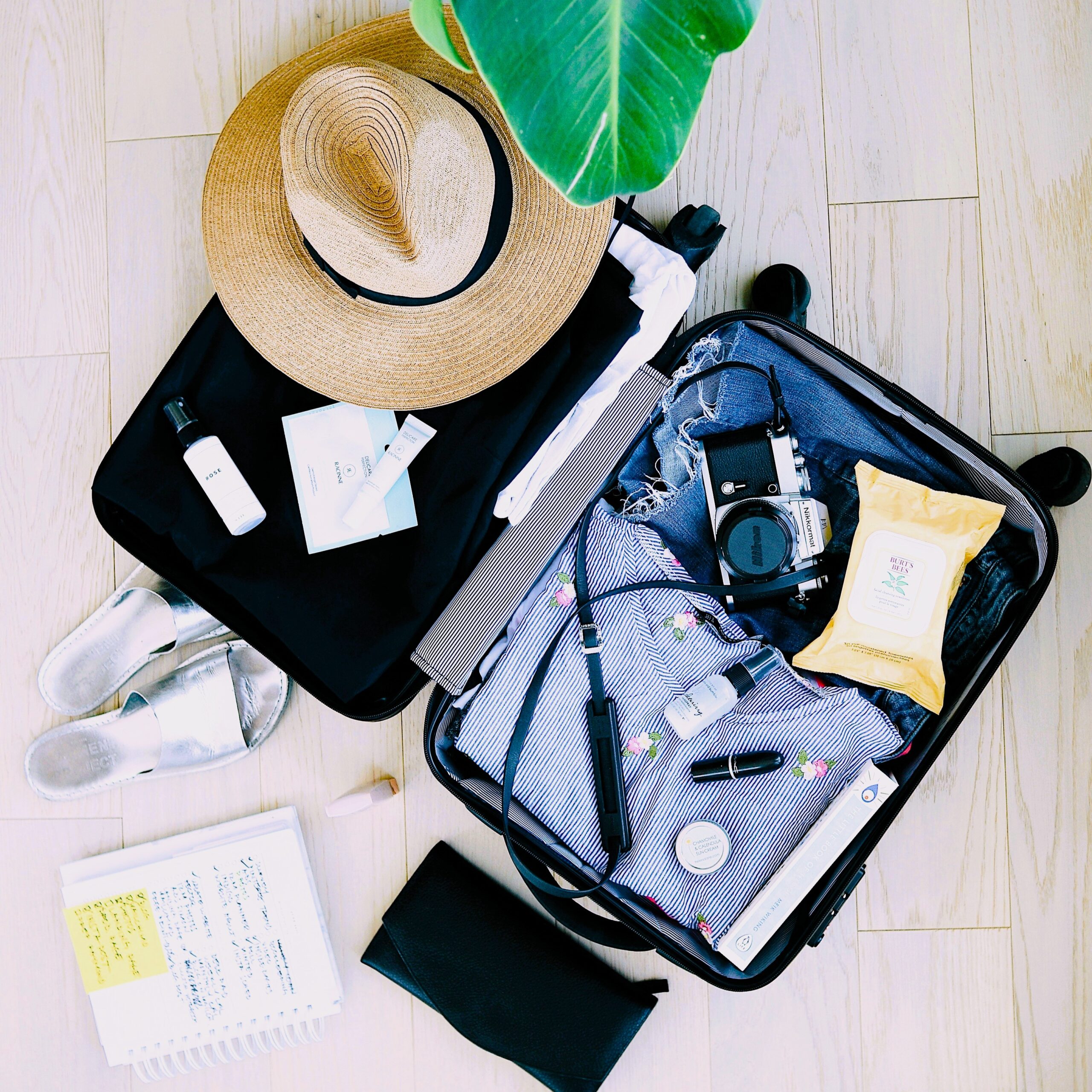 Open suitcase with packed travel essentials and trip preparation items