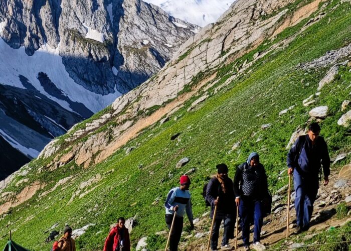Pilgrims trekking along the Amarnath Yatra route with snow-covered Himalayan peaks in Kashmir India Getaways