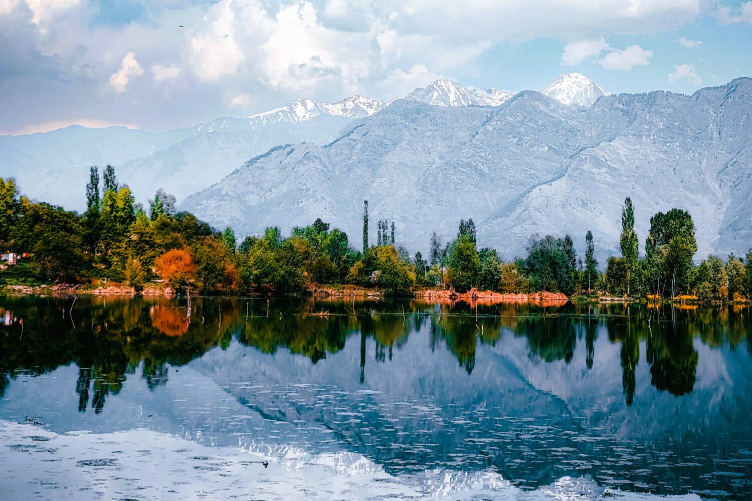 Snow-capped Kashmir mountains reflected in a peaceful alpine lake