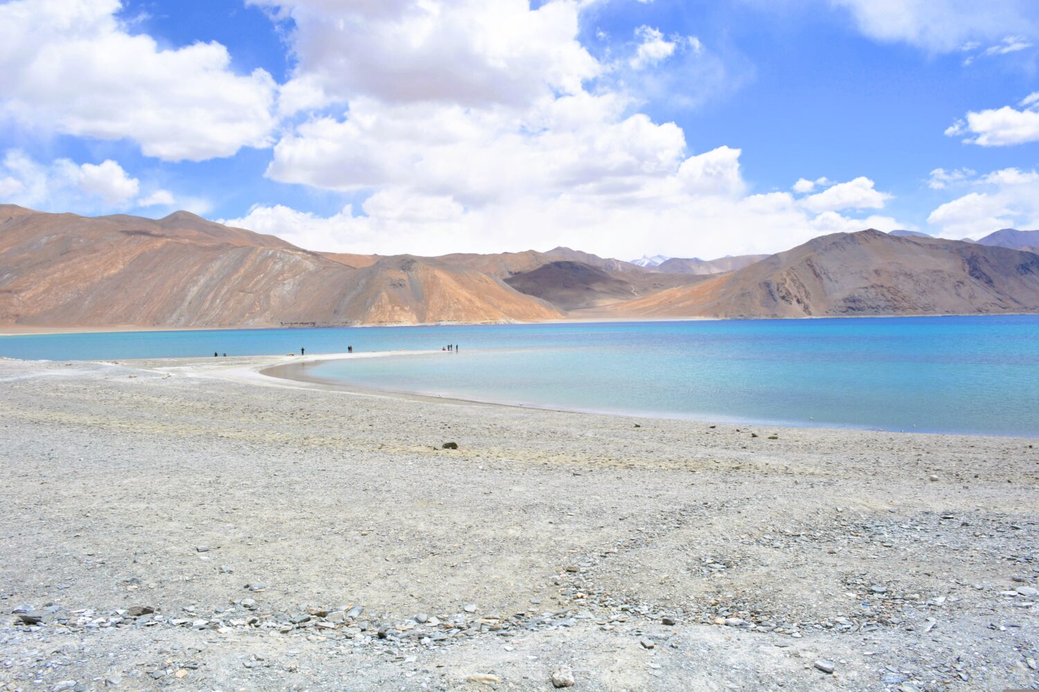Visitors exploring the shoreline of Pangong Lake
