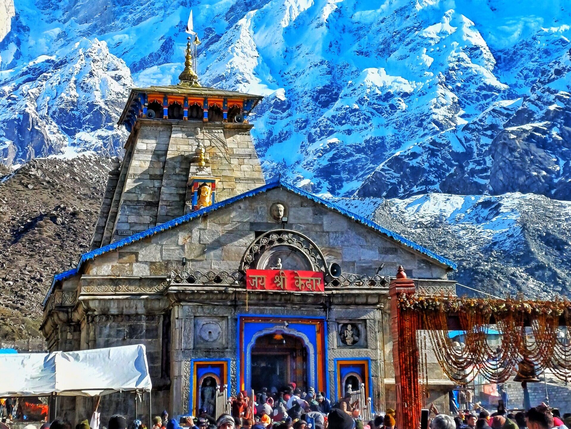 Kedarnath Temple surrounded by snow-covered Himalayan mountains in Uttarakhand featured in Kedarnath Badrinath Yatra Package