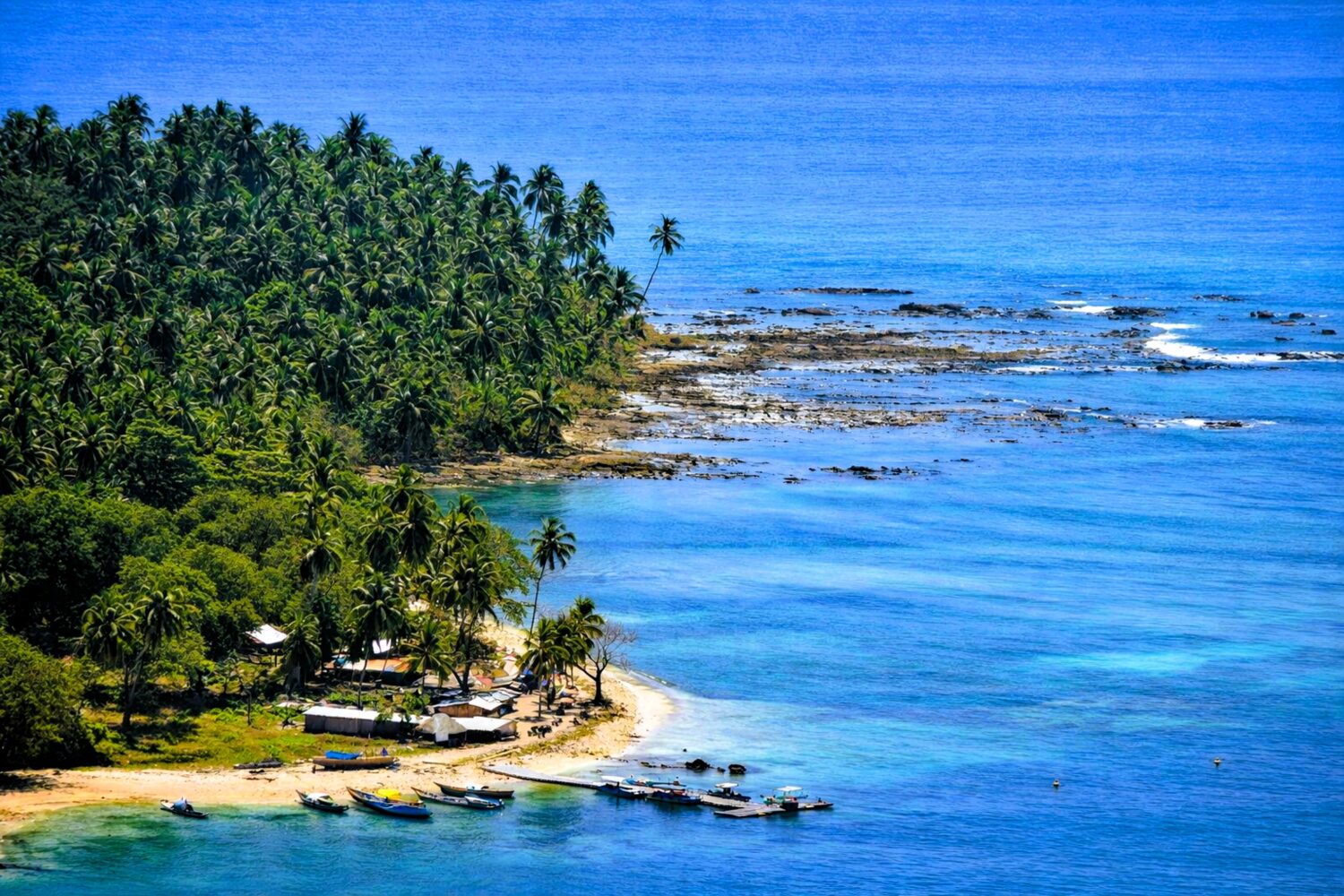 Andaman Islands coastline with tropical beaches, palm trees and boats featured in Andaman Island Tour Package